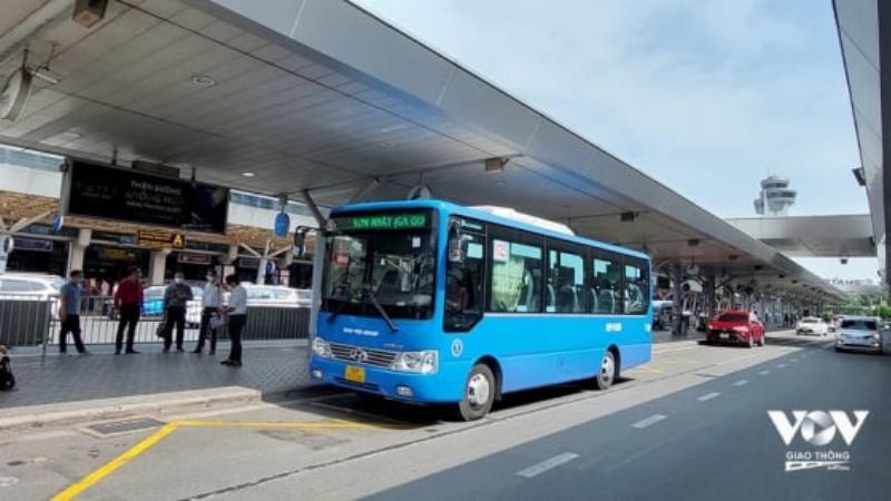 Một hành khách đang sử dụng điện thoại để đặt xe công nghệ tại khu vực chờ sân bay Tân Sơn Nhất, minh họa sự tiện lợi của công nghệ.